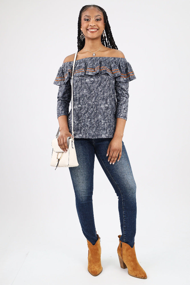 Off shoulder blouse paired with jeans, brown booties, and a white purse